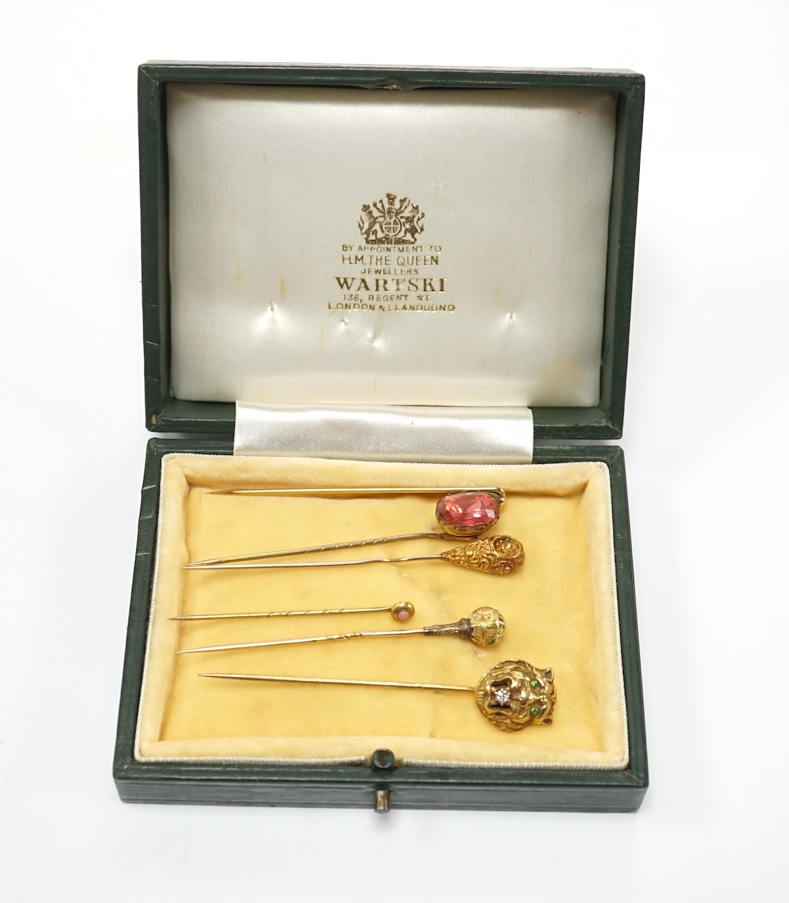 A collection of six assorted mainly early 20th century stick pins including tiger's head set with diamond and green garnets, 68mm. Condition - poor to fair